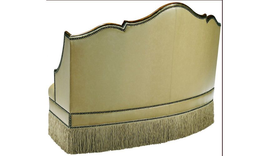 SETTEES, CHAISE, BENCHES Leather settee with wood trim and chic fringed skirt
