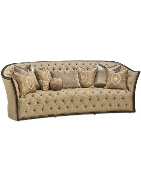 Curved sofa covered in a luxurious tufted oatmeal fabric